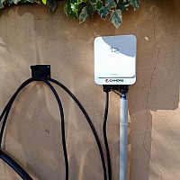 Borne Cahors Boxéo Home 7,4kW avec câble attaché, fixée sur un mur.
